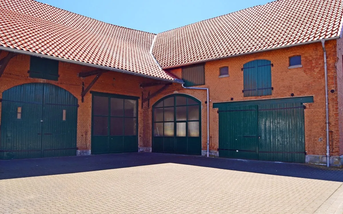 Der Innenhof von Lager Hemmingen mit den historischen Backsteingebäuden und grünen Toren