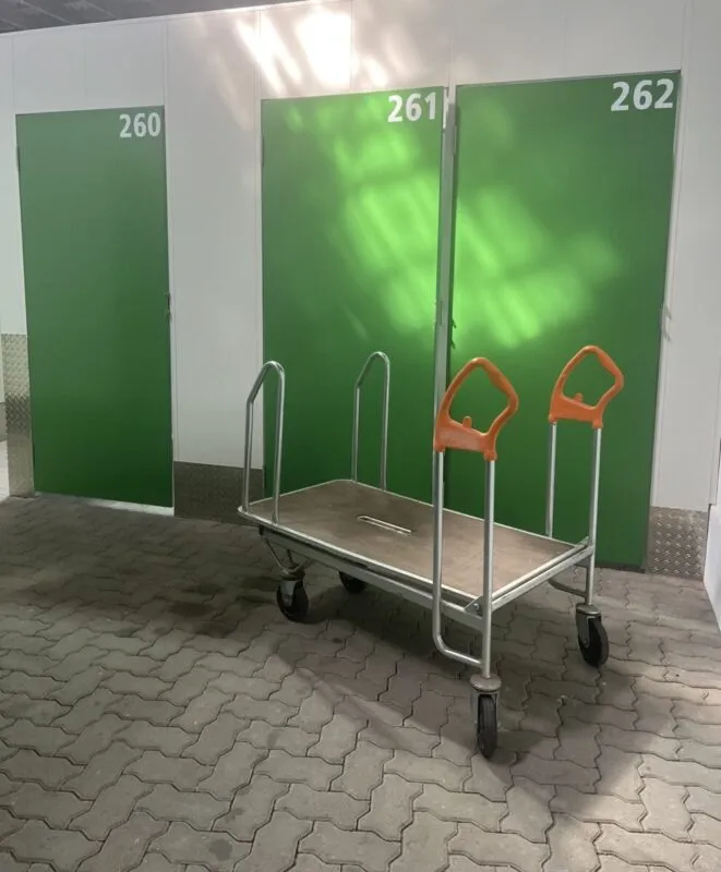 Moderne grüne Lagerabteile mit Rollwagen im Selfstorage-Center